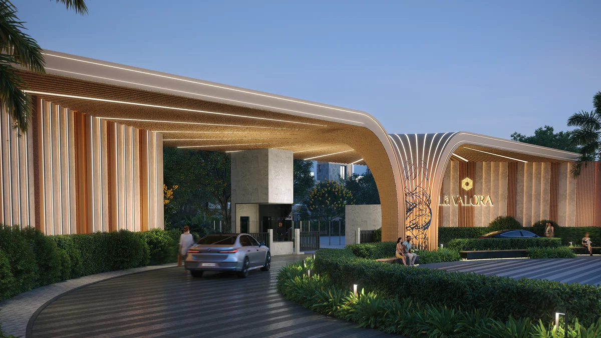 Revasa Là Valora entrance gateway at dusk, a curved slatted canopy over the arrival drive with the Là Valora sign Revasa Là Valora entrance gateway at dusk, a curved slatted canopy over the arrival drive with the Là Valora sign